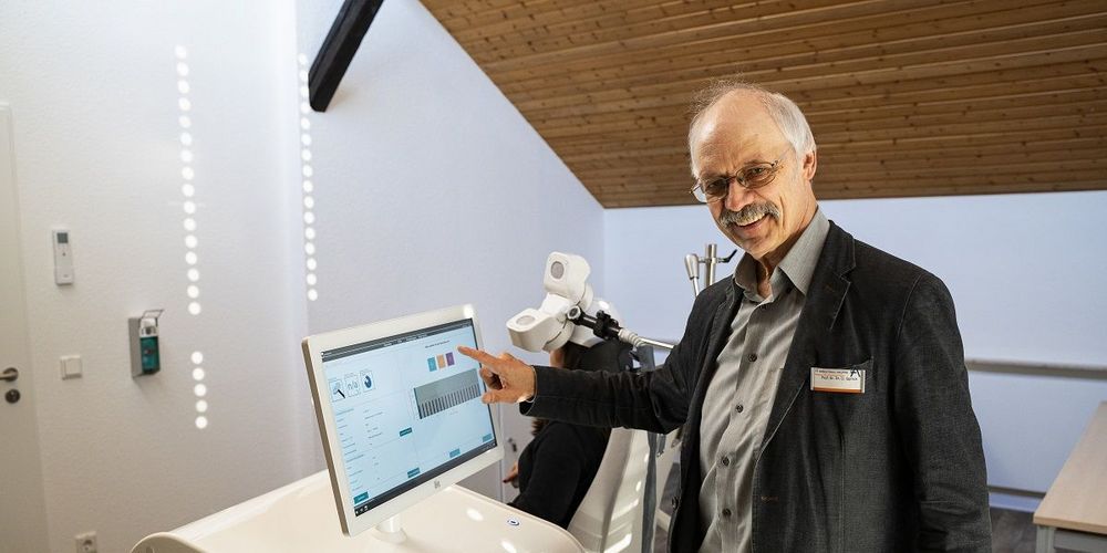 Prof. Dr. Dr. Ulrich Sprick an einem Gerät zur repetitiven transkraniellen Magnetstimulation