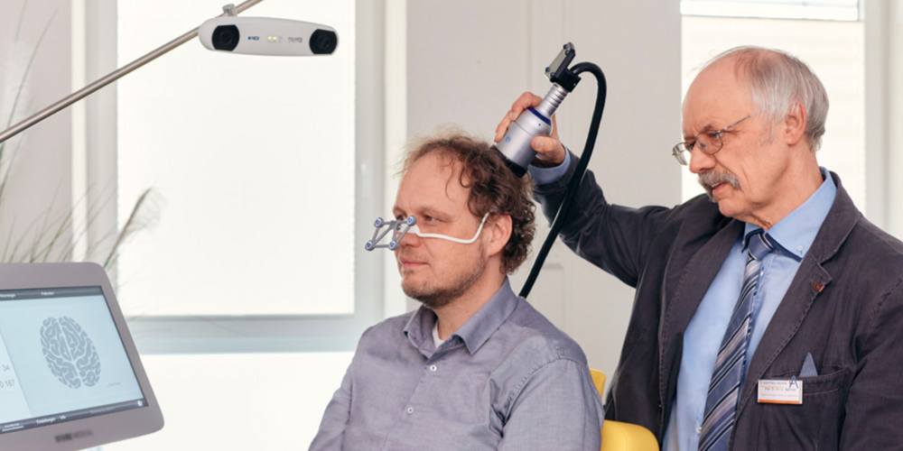 Prof. Dr. Dr. Ulrich Sprick behandelt einen Alzheimer-Patienten mit der Transkraniellen Pulsstimulation